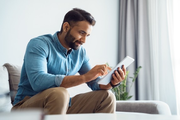 Mann sitzt am Tablet