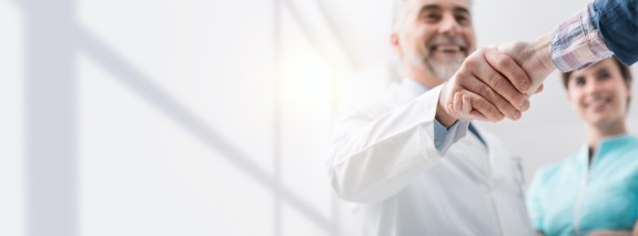 Zahnarzt schüttelt Patient die Hand